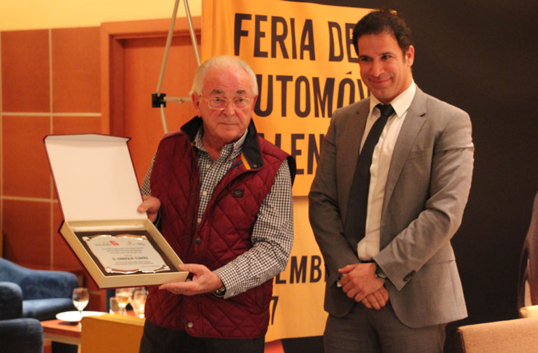 Enrique Tomás recibe de Raúl Palacios una placa de homenaje.