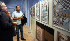 El alcalde de Chelva, David Cañigueral y la concejala de fiestas, Clara Folgado, visitando la exposición y atendiendo a las explicaciones de José Antonio Garzón