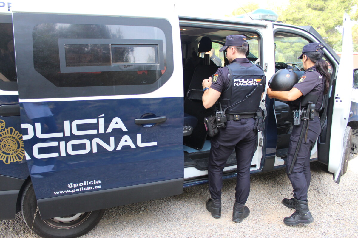 Dos agentes junto a un furgón de la Policía Nacional