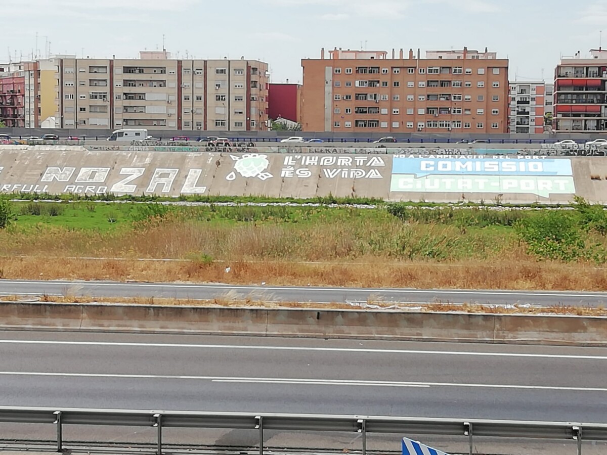 GRafiti en el nuevo cauce del Túria contra la ampliación del Puerto de València