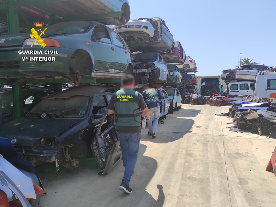 Dos agentes de la Guardia Civil inspeccionan un desguace