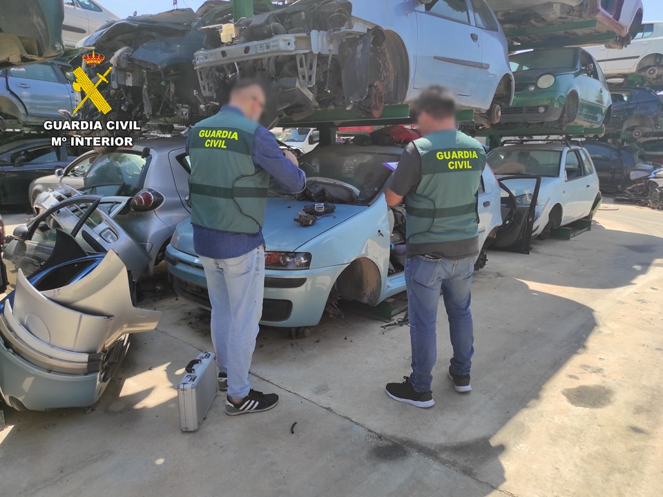 Dos agentes de la Guardia Civil inspeccionan un desguace