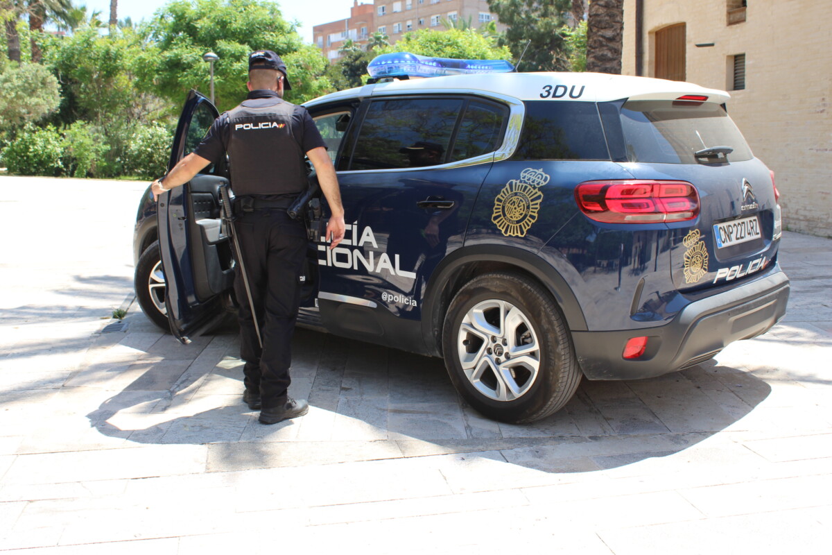 Un agente de la Policía Nacional entra en su coche patrulla