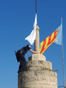 Un policía local retira una bandera con versos del Corán de las Torres de Serranos