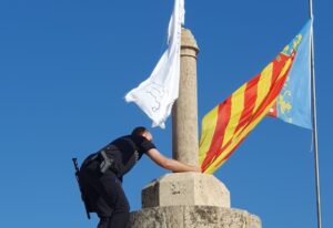 Un policía local retira una bandera con versos del Corán de las Torres de Serranos