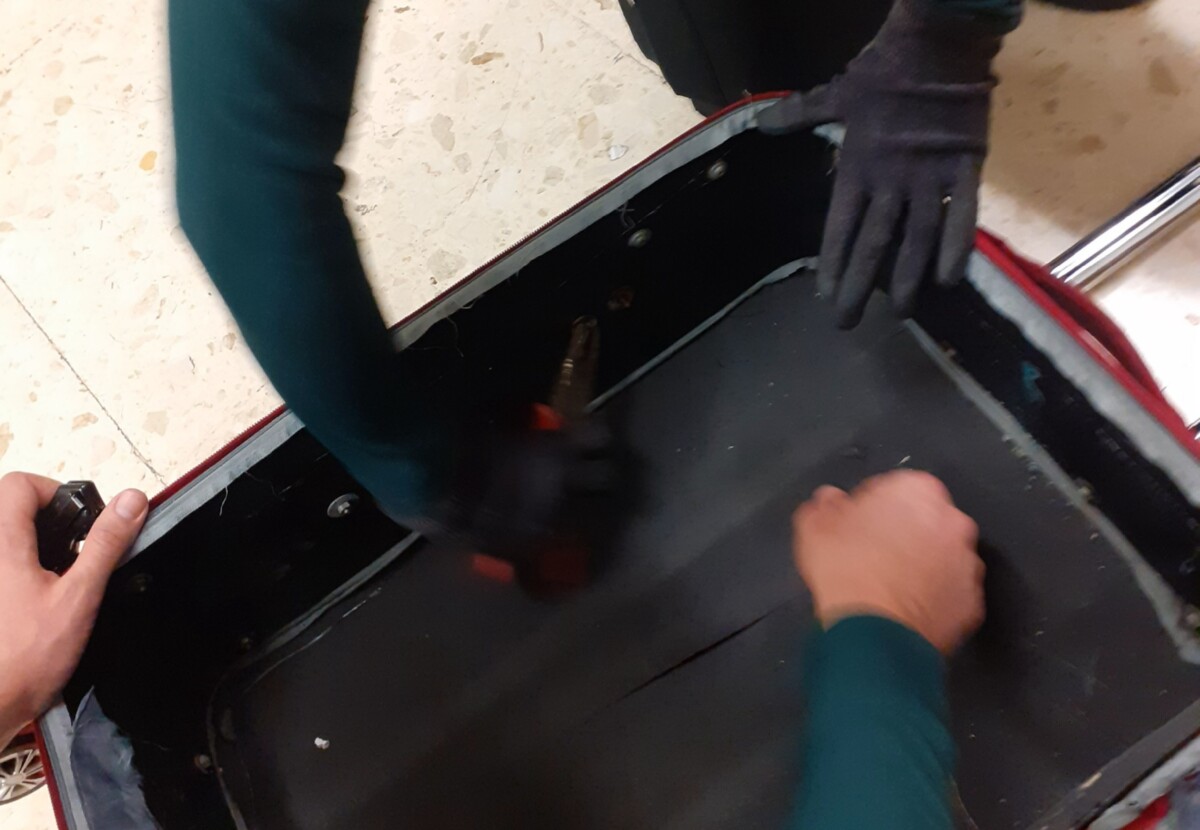 Un agente de la Guardia Civil inspecciona la maleta de un pasajero