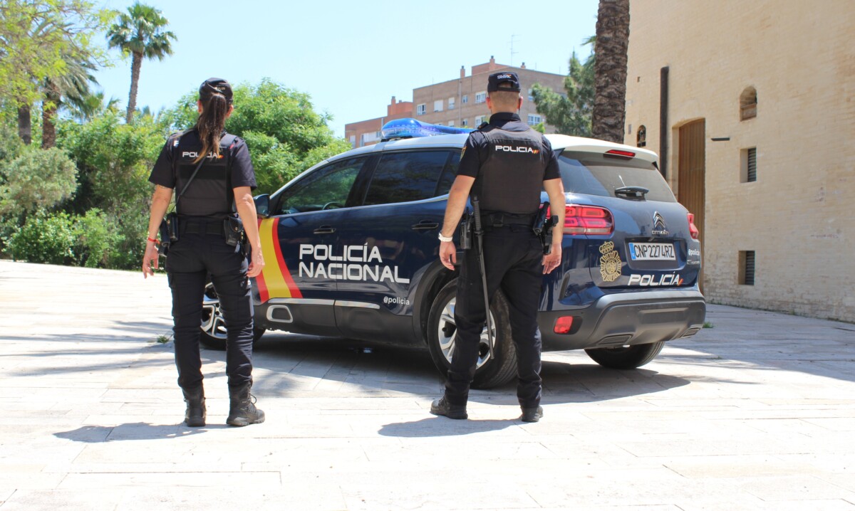 Agentes de la Policía Nacional junto a un coche patrulla