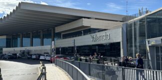 Vista exterior del aeropuerto de Manises en Valencia con personas y coches