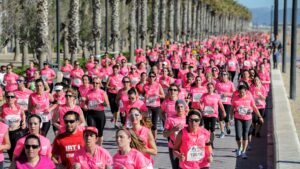 Mujeres corriendo en la Carrera Dona de Valencia con camisetas rosas