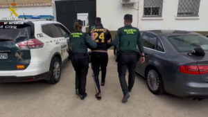 Dos agentes de la Guardia Civil conducen al detenido