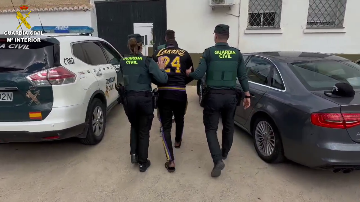 Dos agentes de la Guardia Civil conducen al detenido