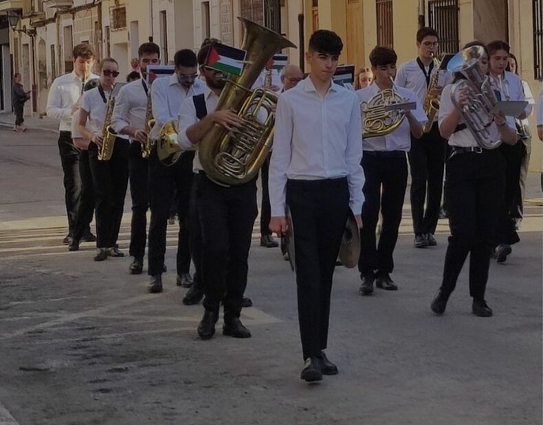Músicos de la Agrupación Musical de Rocafort con la cartulina de la bandera de Palestina en la procesión del Corpus