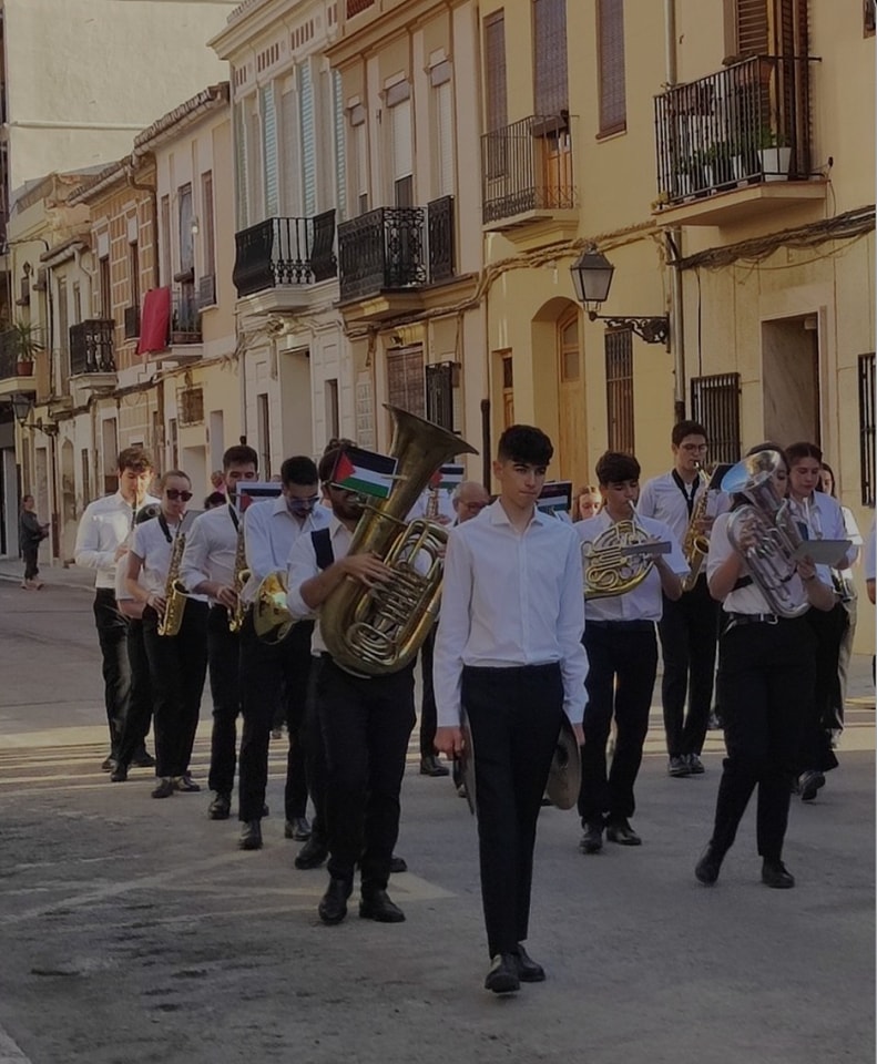 Músicos de la Agrupación Musical de Rocafort con la cartulina de la bandera de Palestina en la procesión del Corpus