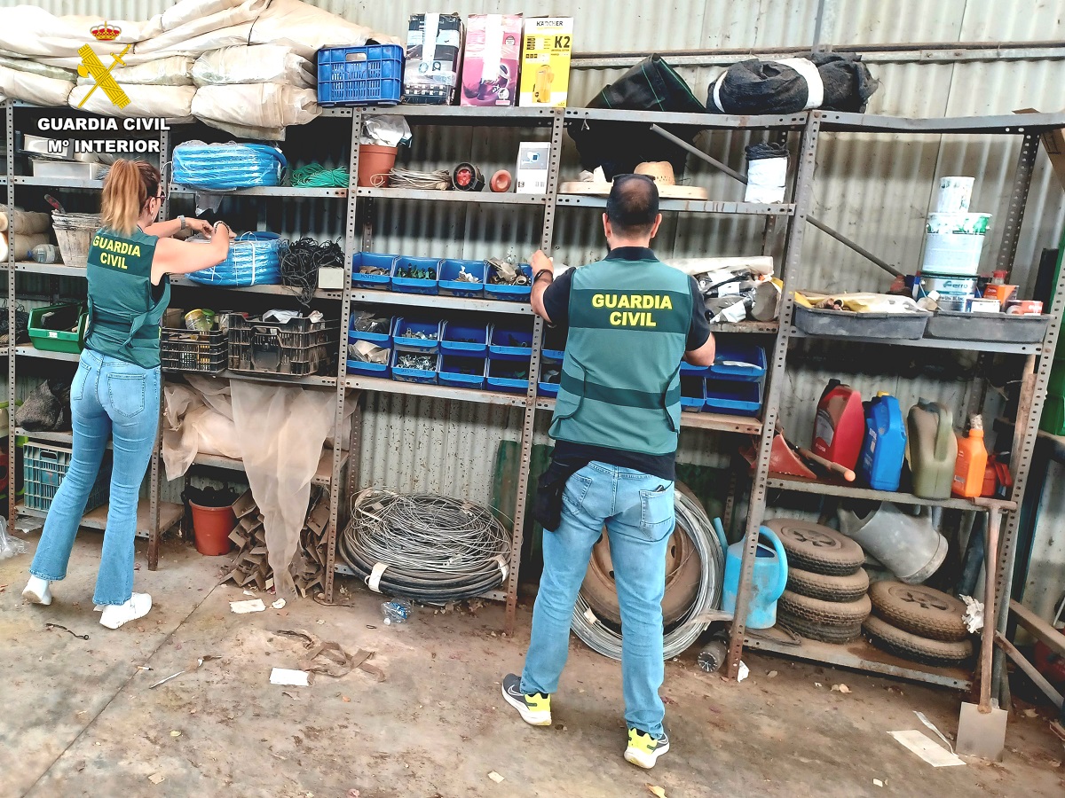 Dos agentes de la Guardia Civil inspeccionan un almacén