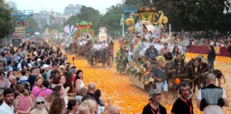 Desfile de carrozas en la Batalla de Flores en Valencia con público disfrutando.
