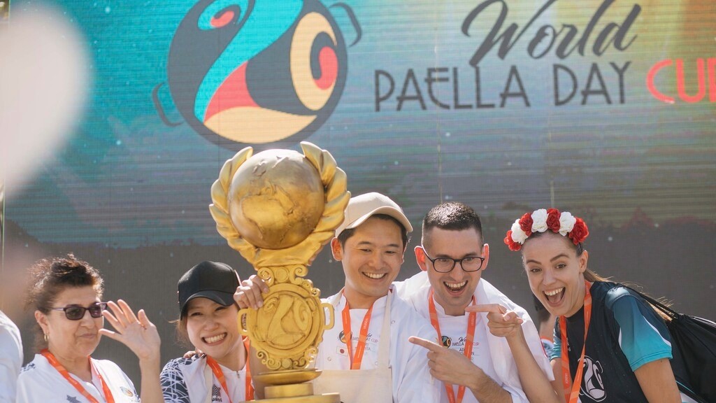 Participantes del World Paella Day Cup sosteniendo el trofeo