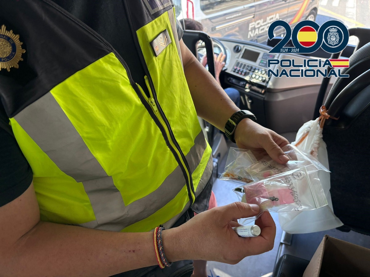 Agente de la Policía Nacional con bolsas de droga encontradas en un autobús