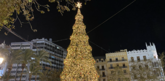Árbol de Navidad iluminado en Valencia durante la noche.