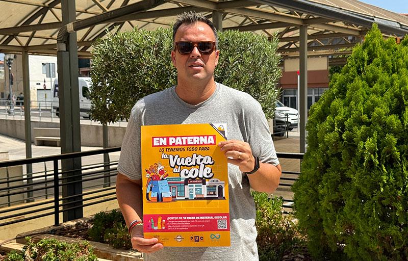 Hombre sosteniendo un cartel de la campaña de vuelta al cole en Paterna.