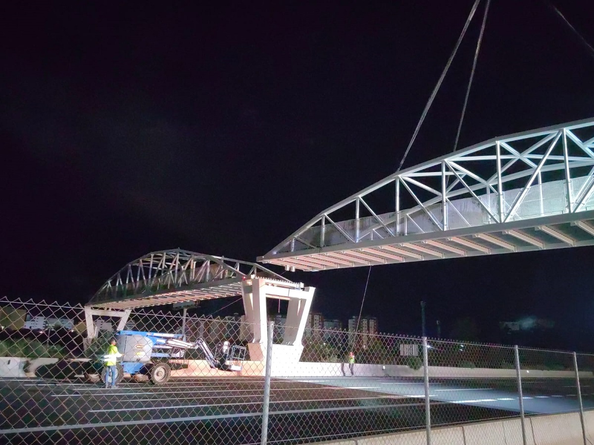 Instalación nocturna de la pasarela ciclopeatonal sobre la V-21 en Pobla de Farnals