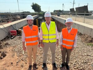 Tres hombres en un sitio de construcción con chalecos reflectantes