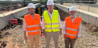 Tres hombres en un sitio de construcción con chalecos reflectantes