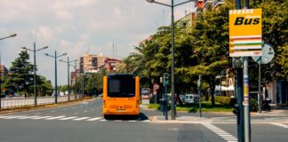 Parada de MetroBus en Torrent con autobús amarillo en la calle