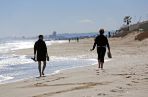 Dos personas pasean por la playa de la Garrofera-El Saler. EFE/Manuel Bruque/Archivo