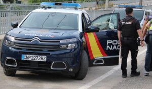Coche patrulla y agente de la Policía Nacional