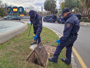 Dos agentes de la Policía Nacional inspeccionan una alcantarilla. Foto de archivo