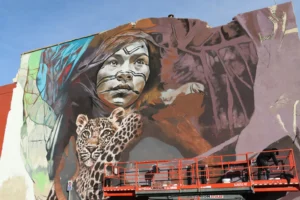 Mural artístico en Torrent con un retrato y un jaguar.