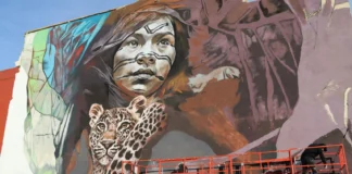Mural artístico en Torrent con un retrato y un jaguar.