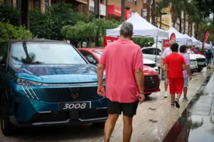 Personas caminando entre coches en la Fira de l'Automòbil de Torrent
