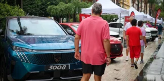 Personas caminando entre coches en la Fira de l'Automòbil de Torrent