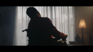 Silhouette de un hombre en silla de ruedas en un ambiente oscuro