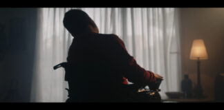 Silhouette de un hombre en silla de ruedas en un ambiente oscuro