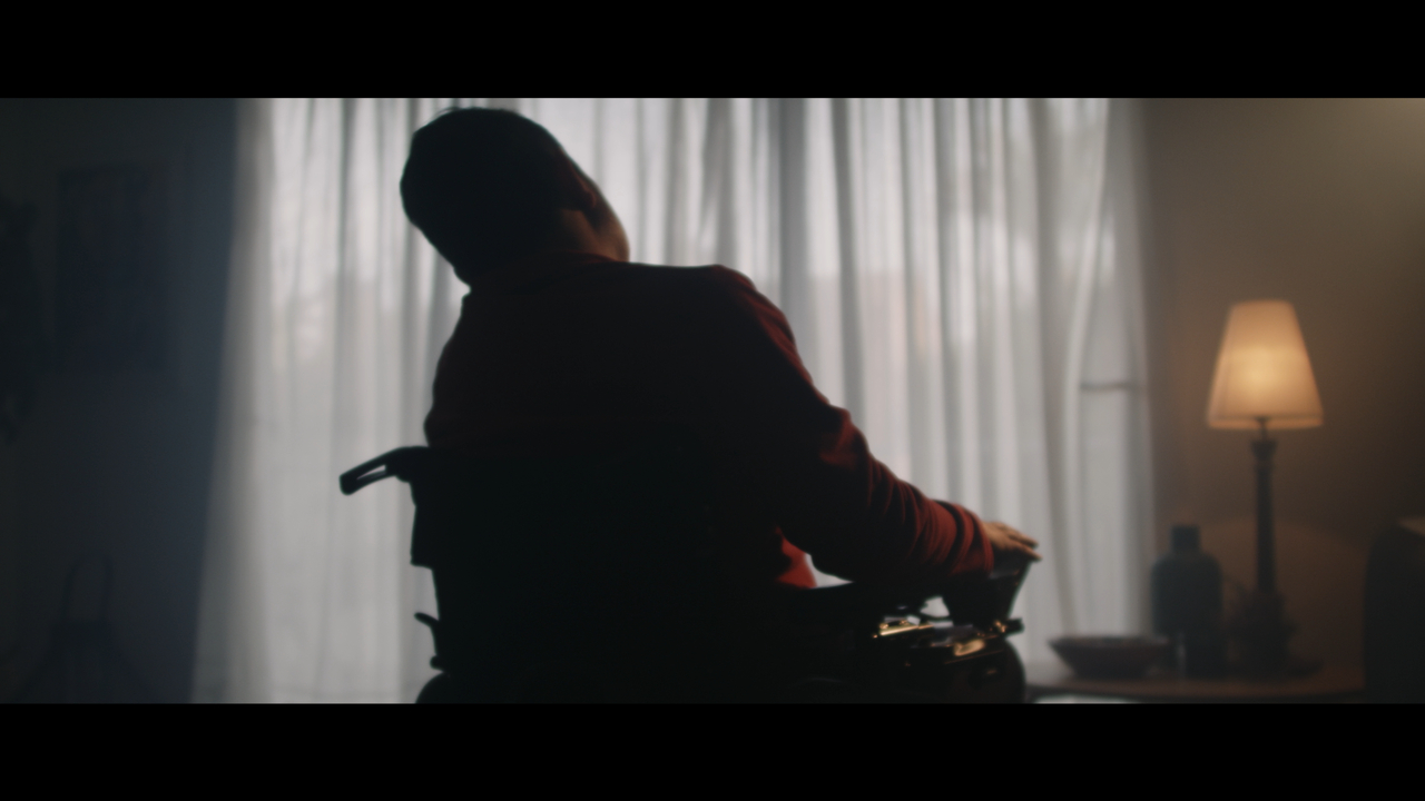 Silhouette de un hombre en silla de ruedas en un ambiente oscuro