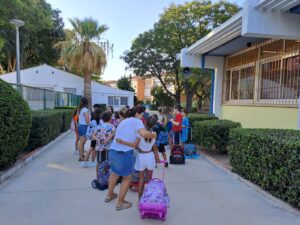 Grupo de niños con mochilas en la entrada de la escuela