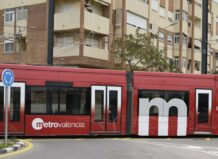 Tram de Metrovalencia en una curva cerca de edificios residenciales
