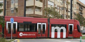 Tram de Metrovalencia en una curva cerca de edificios residenciales