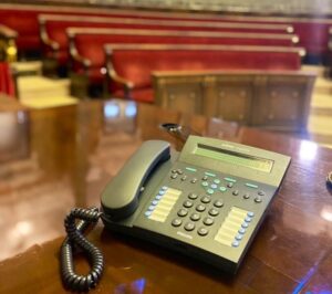Teléfono sobre una mesa en un salón con asientos rojos