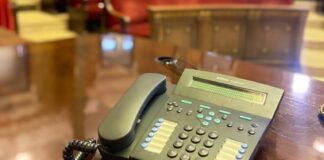 Teléfono sobre una mesa en un salón con asientos rojos