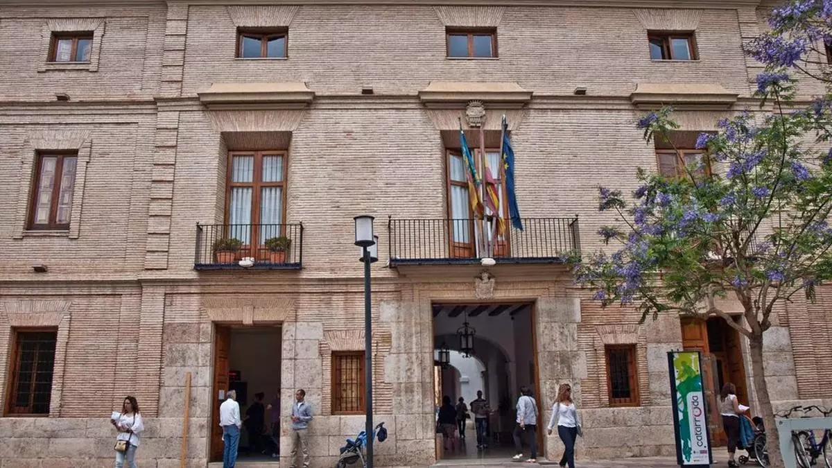 Fachada del Ayuntamiento de Catarroja con banderas y personas