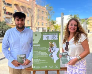 Dos personas sosteniendo un cartel sobre la celebración del 9 de octubre en Moncada