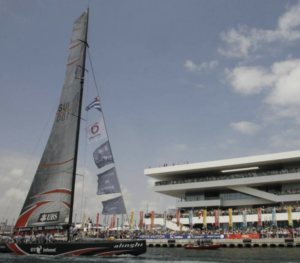 Yate de la Copa América navegando en Valencia con espectadores en el puerto
