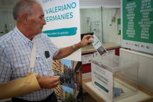 Persona depositando su voto en la urna de la enquesta ciutadana sobre arbratge