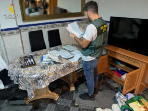 Agente de la Guardia Civil revisando documentos en un hogar desmantelado en Torrent