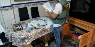 Agente de la Guardia Civil revisando documentos en un hogar desmantelado en Torrent