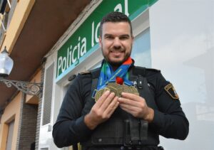 Agente de policía local de Picanya sosteniendo medallas de oro