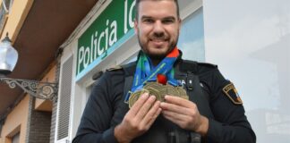 Agente de policía local de Picanya sosteniendo medallas de oro